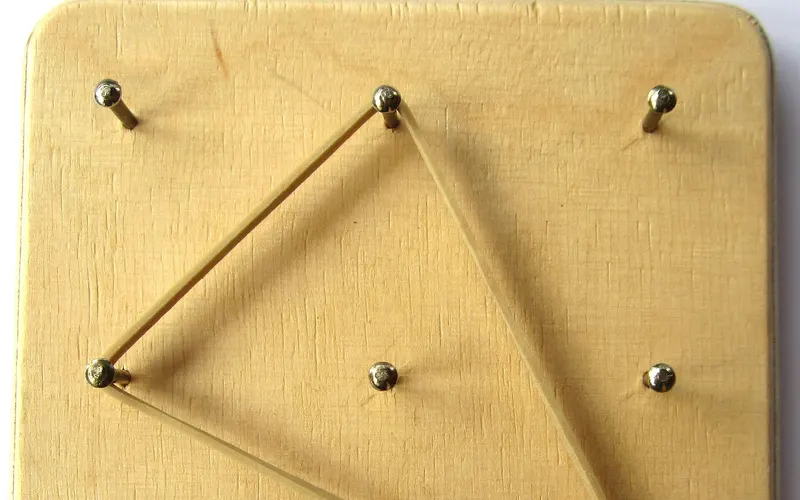 A 3 X 3 wooden geoboard with triangle made with elastic band