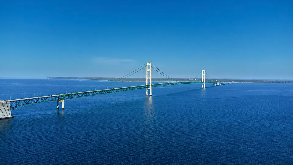 A long suspension bridge crossing a wide strait between two lakes.