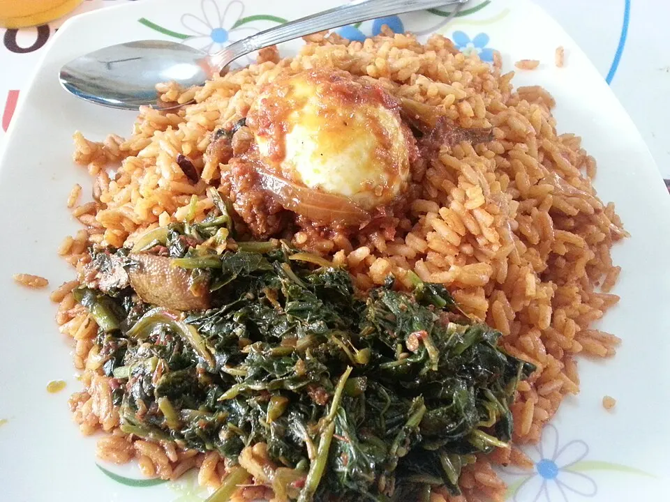 A plate of orange-red spiced rice with chicken.