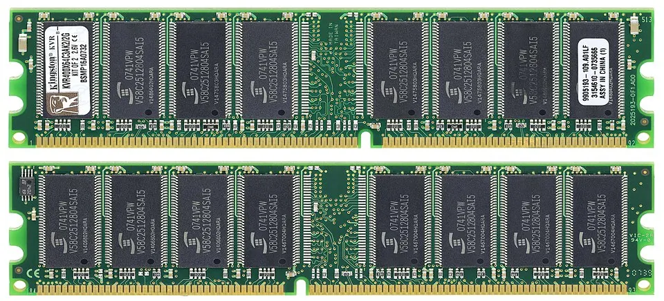 Two long green memory circuit boards, each lined with black chips and gold contacts along the bottom edge.
