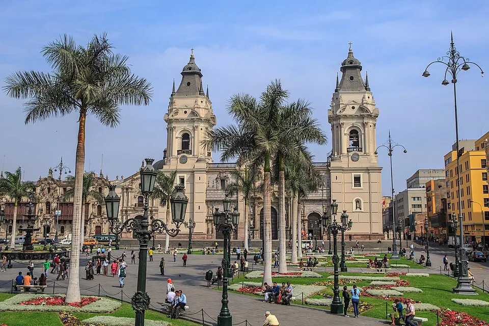 A grand colonial square with a cathedral and balconied buildings.