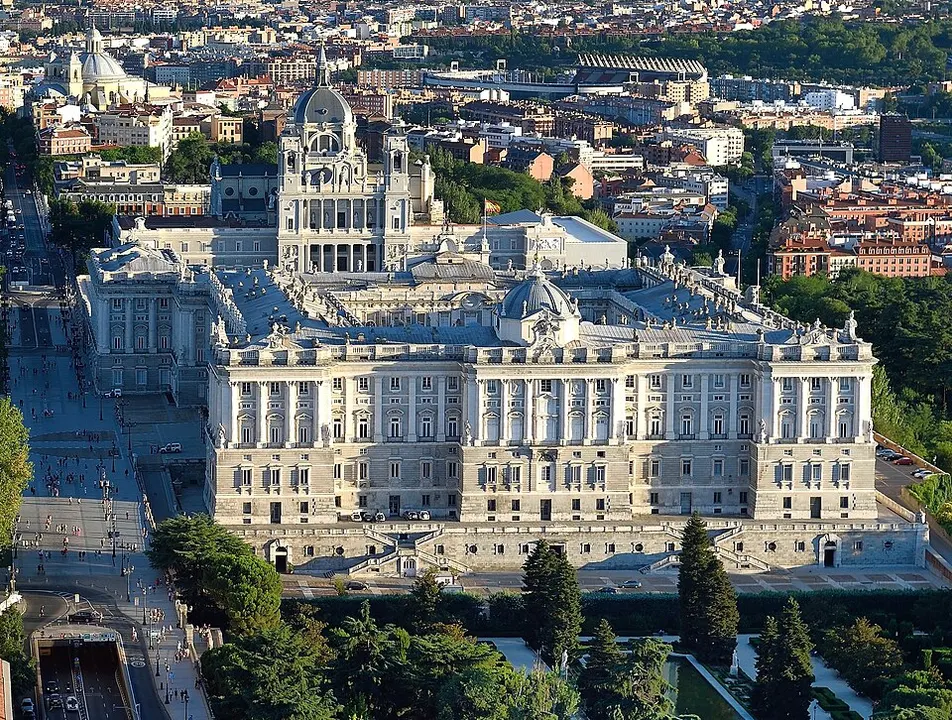 A grand white palace facade with columns and a wide plaza in front.