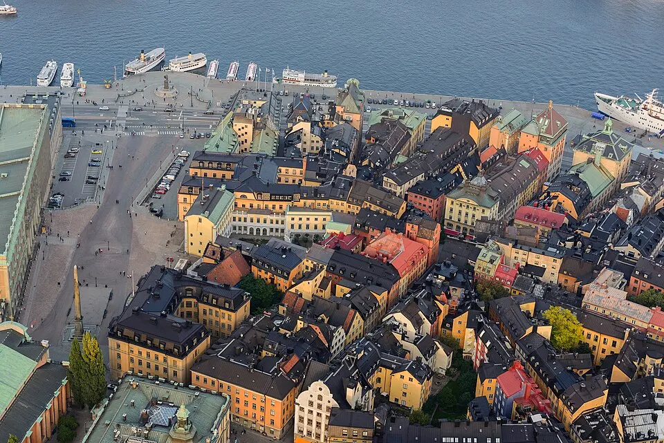 Colourful old waterfront buildings and a palace on a small island.