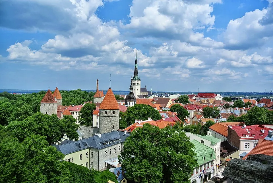 Red-roofed medieval buildings and church spires of an old walled town.