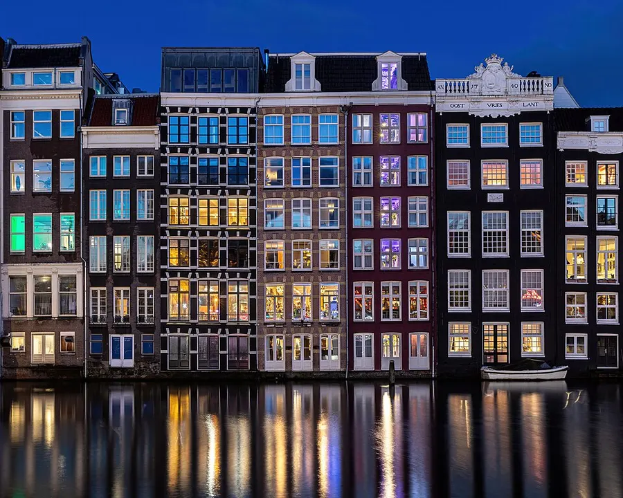 Narrow gabled houses lining a canal with bicycles and boats.