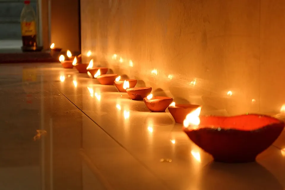 Rows of small clay lamps glowing in the dark.