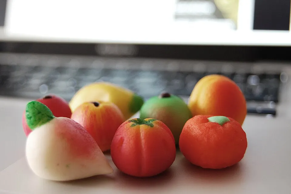 Small colourful sweets shaped like fruit, made of a pale paste.