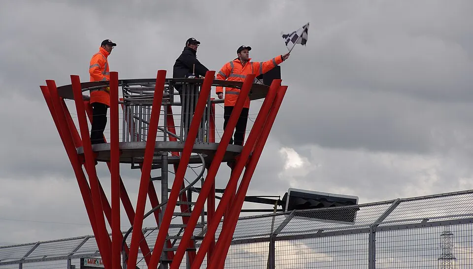 A black and white checked flag being waved at a track.