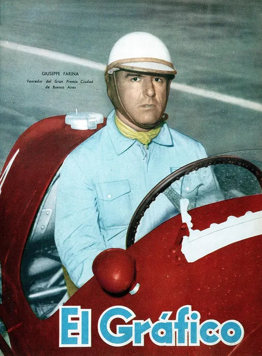 A vintage black-and-white portrait of a driver in a racing helmet.