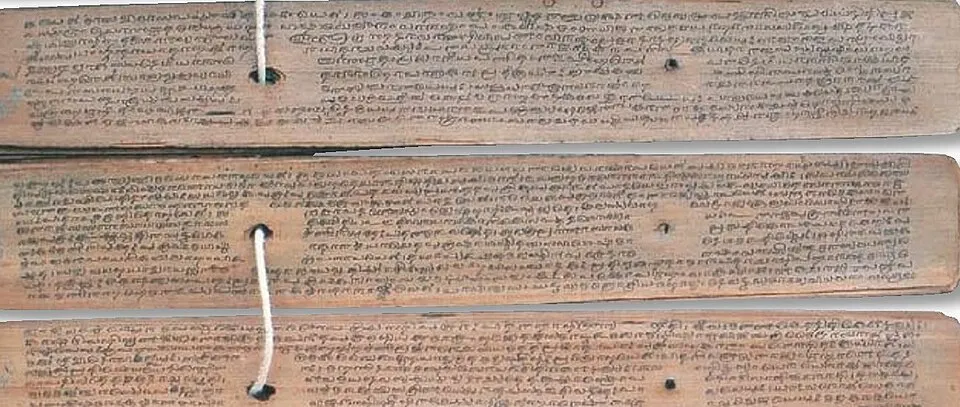 Several long strips of palm leaf strung together on a cord, covered in handwritten lines of old script.