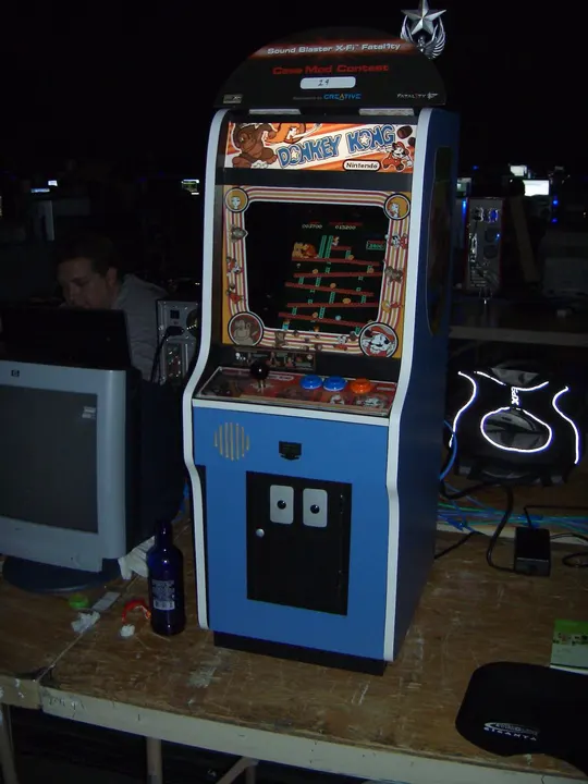 An upright arcade cabinet with a blue lower body, a colourful marquee and a small screen showing platforms and ladders.