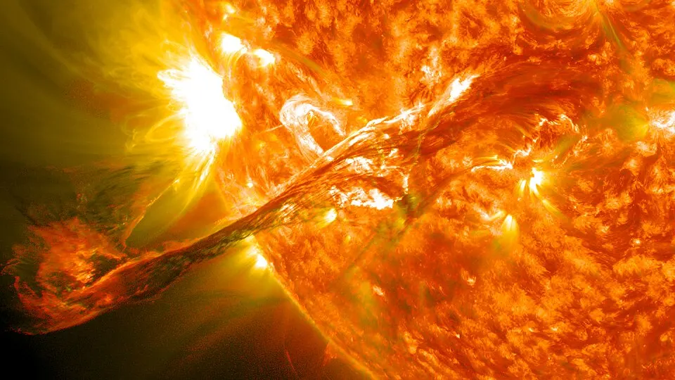 A glowing orange ball of fire with a long loop of bright material streaming out into space.