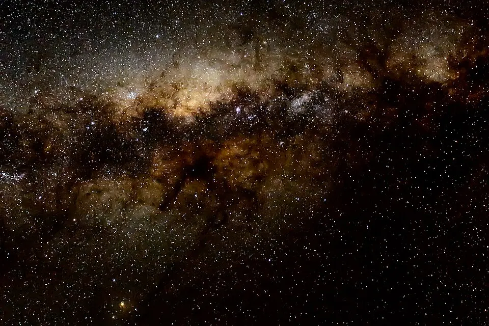 A dark night sky filled with countless tiny stars and a glowing band of light.