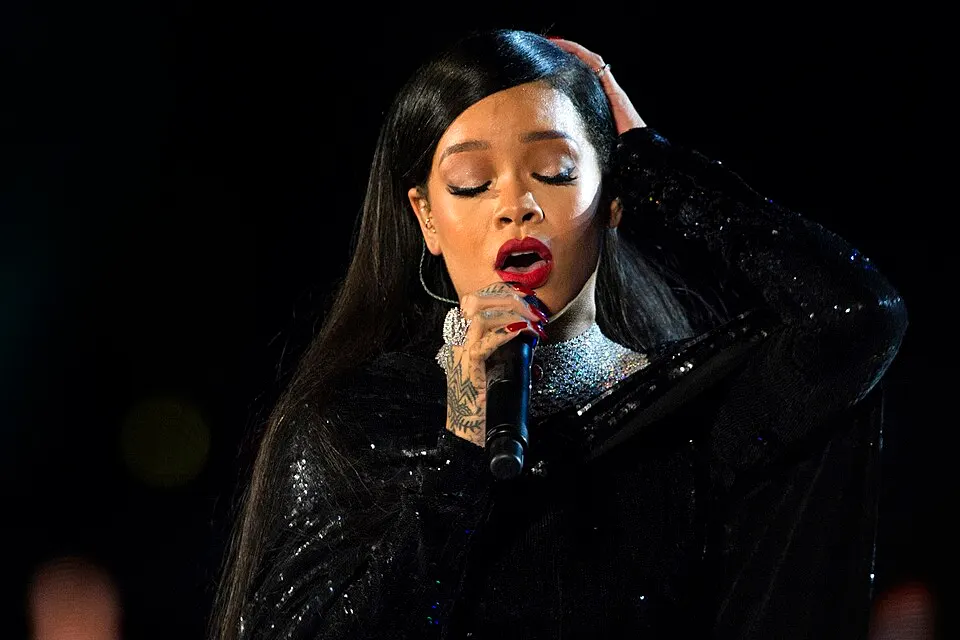A woman singing on stage under bright lights.