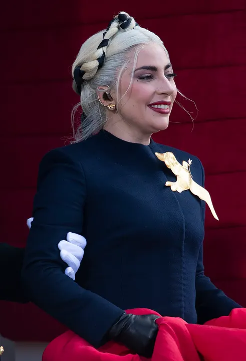 A woman with platinum hair performing under spotlights.