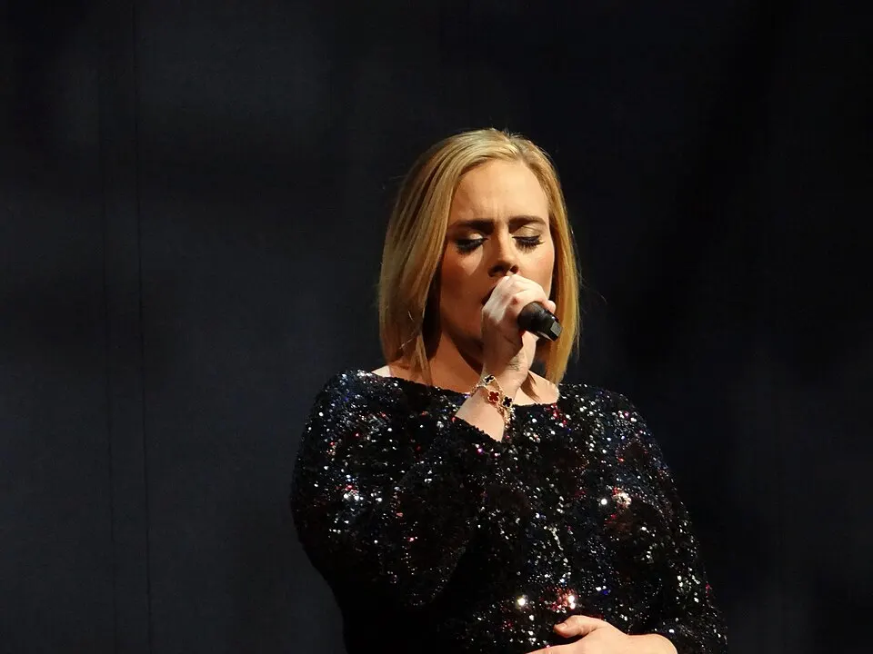 A woman with blonde hair singing into a microphone.