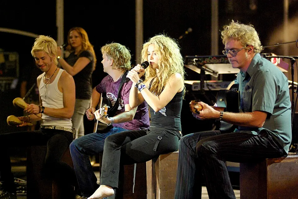 A woman with long wavy hair performing on stage.