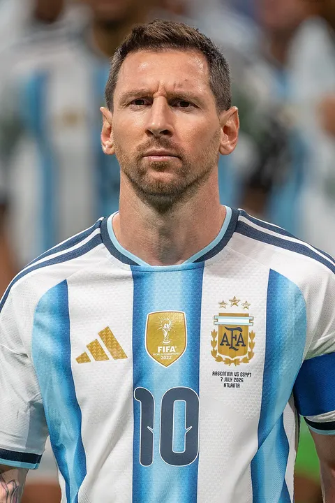 A footballer with a beard in a light-blue and white striped kit.