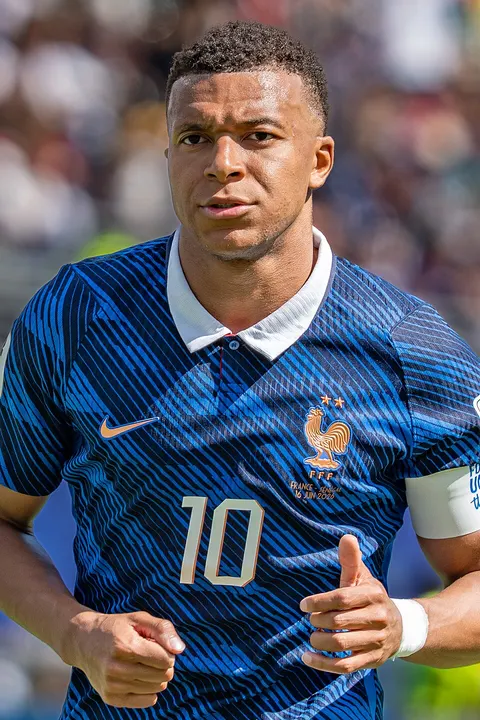 A young striker in a blue national-team kit mid-match.