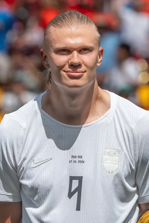 A tall blond footballer in a white kit.