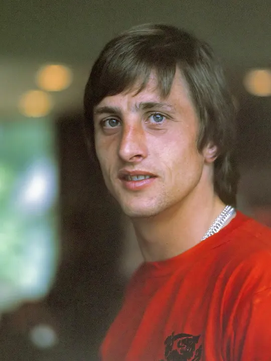 A footballer with shoulder-length hair in an orange Dutch shirt.