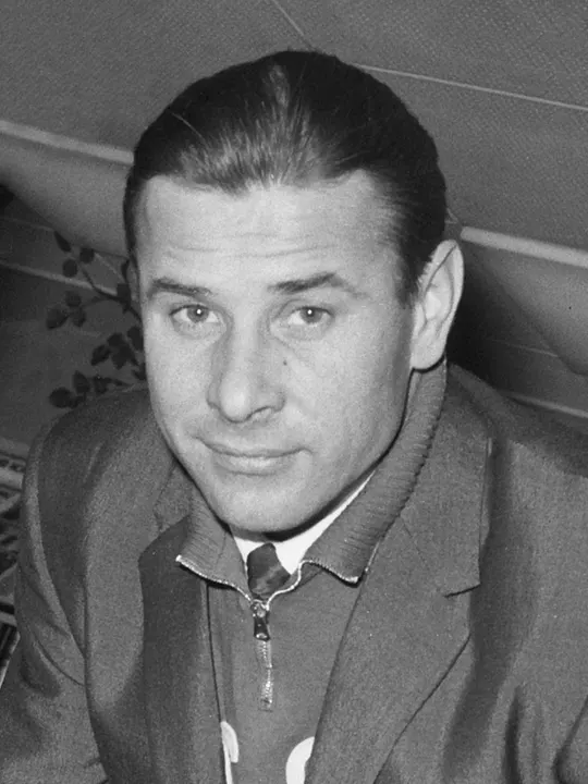 A black-and-white photo of a goalkeeper in a dark jersey and cap.