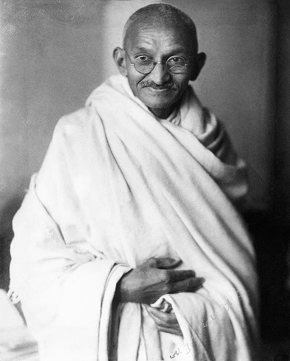 A bespectacled man in a plain white shawl.