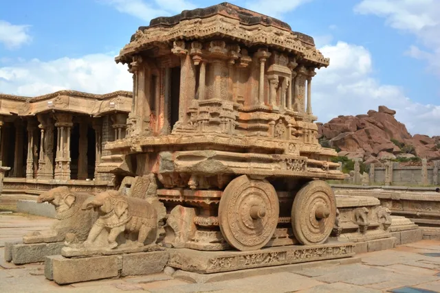 Ornate stone shrine carved in the shape of a chariot with stone wheels