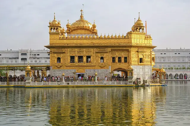 Gilded shrine with small domes reflected in a large pool