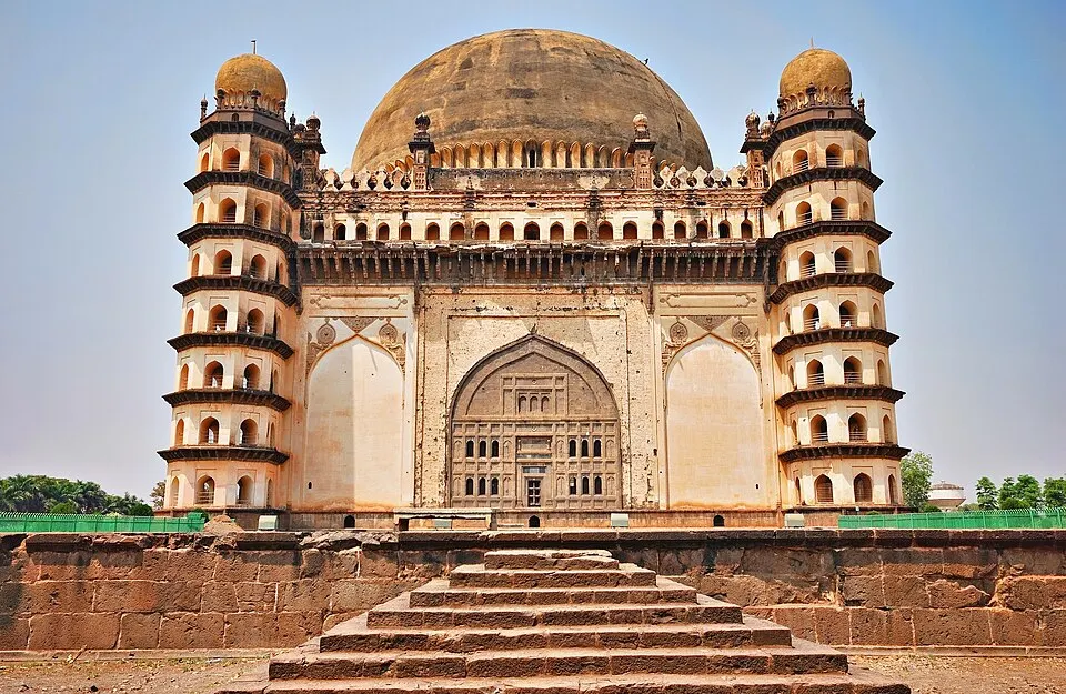 A huge square tomb with a massive rounded dome and an octagonal tower at each corner, seen from the top of a flight of steps.