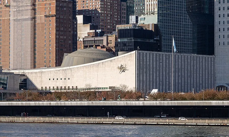 A large circular assembly hall with rows of desks facing a podium.