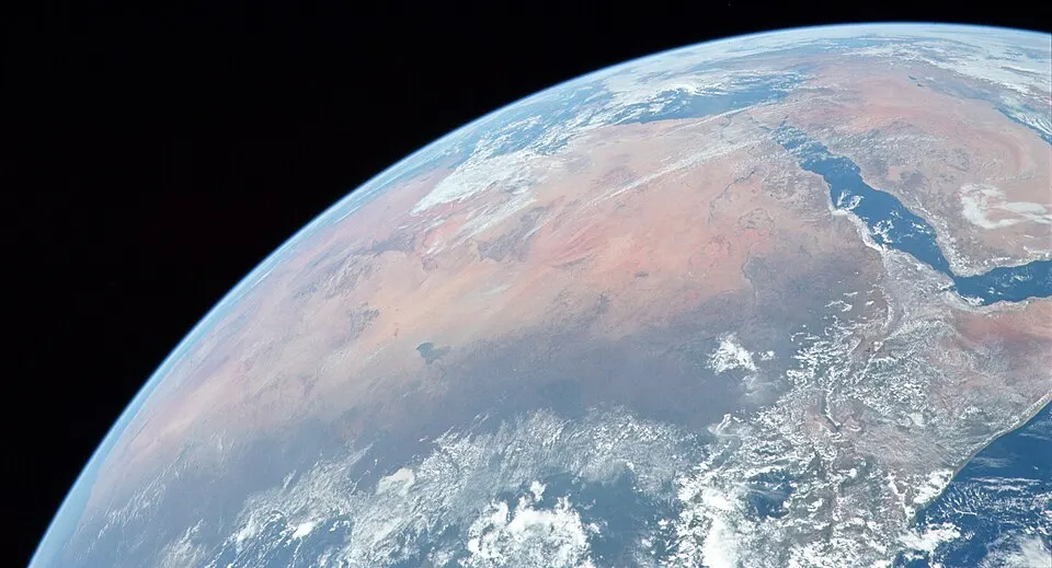 A view from space of a vast orange-brown desert across a continent.