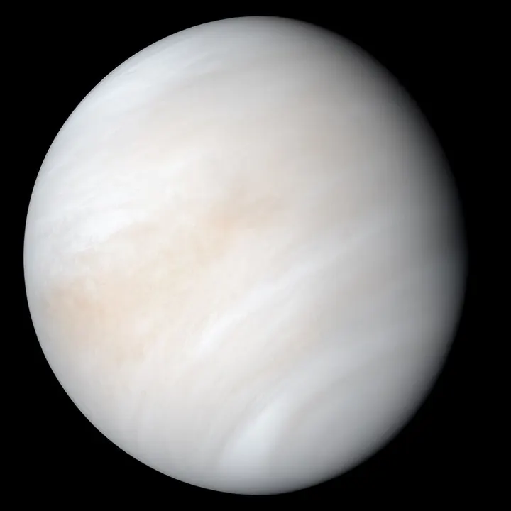 A pale, cloud-wrapped globe with a smooth yellowish surface.