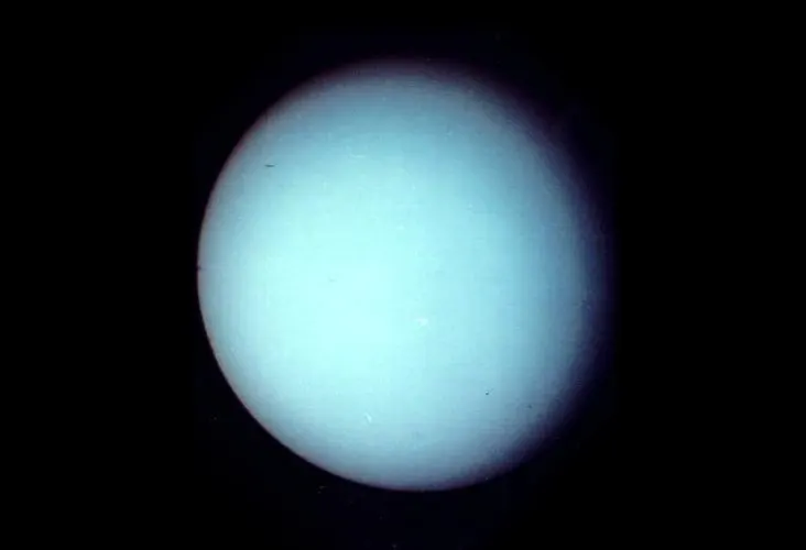 A pale blue-green globe with faint cloud bands.