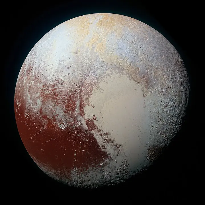 A small, mottled, tan-and-white world with a pale heart-shaped patch.