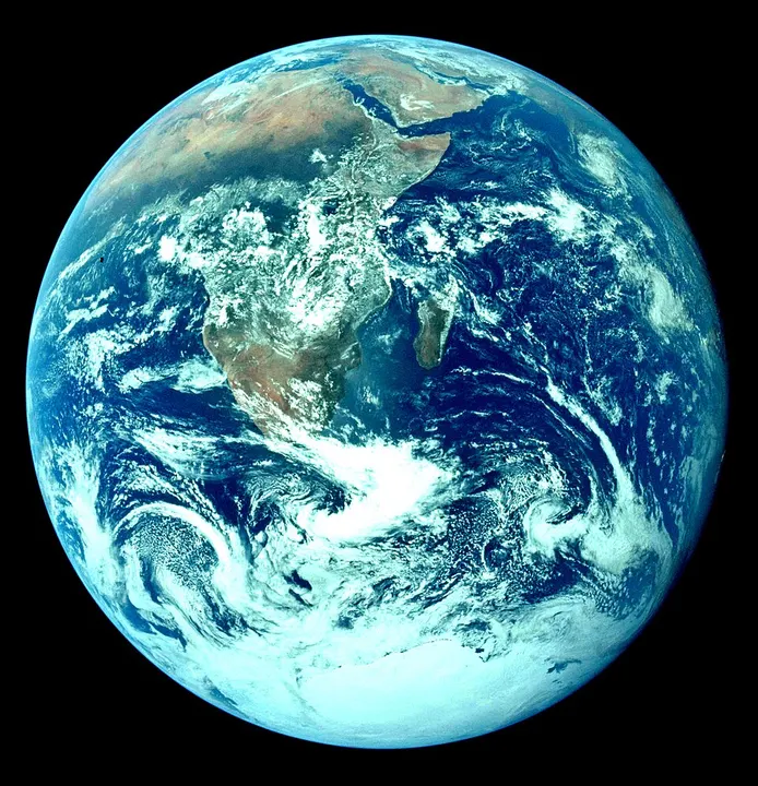 The whole Earth seen from space, with blue oceans, white clouds and brown land.