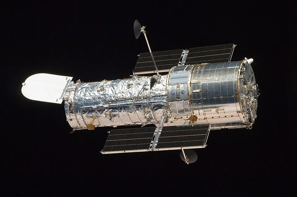 A cylindrical telescope with two solar wings floating above Earth.