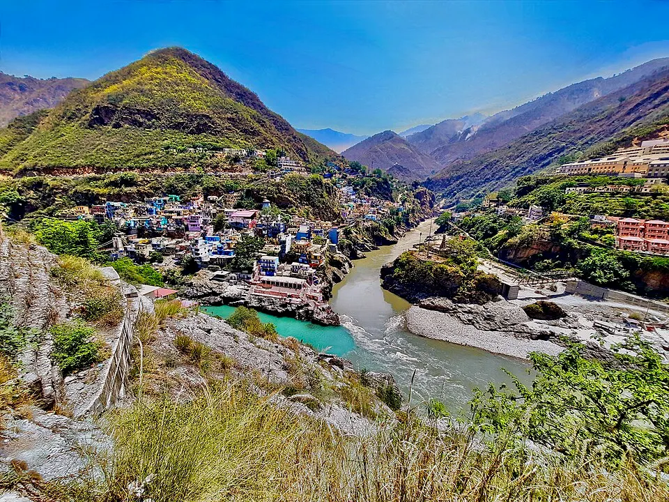 पहाड़ियों के बीच बसे कस्बे के पास दो नदियों का संगम, जहाँ एक का पानी हरा-नीला और दूसरे का मटमैला है।