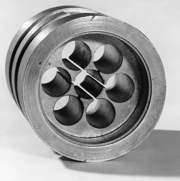 A small metal radar component with cut-out chambers.