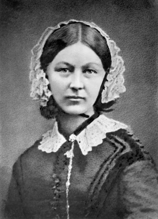 A Victorian portrait of a woman in a dark dress and white cap.