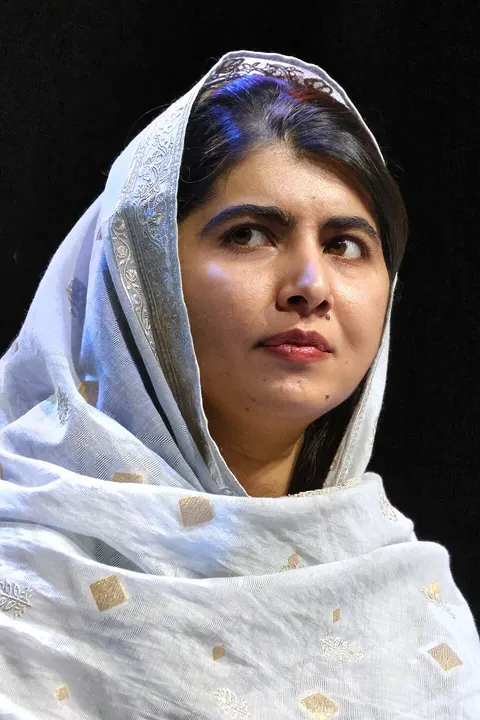 A young woman in a headscarf speaking.