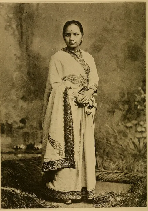 An old photograph of a young woman in a sari.
