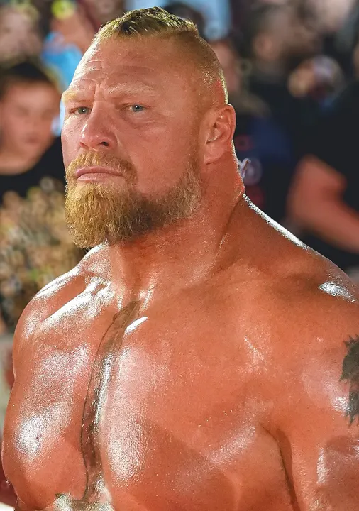 A large muscular bald man with a goatee.