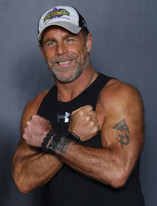 A wrestler with shoulder-length hair, smiling.